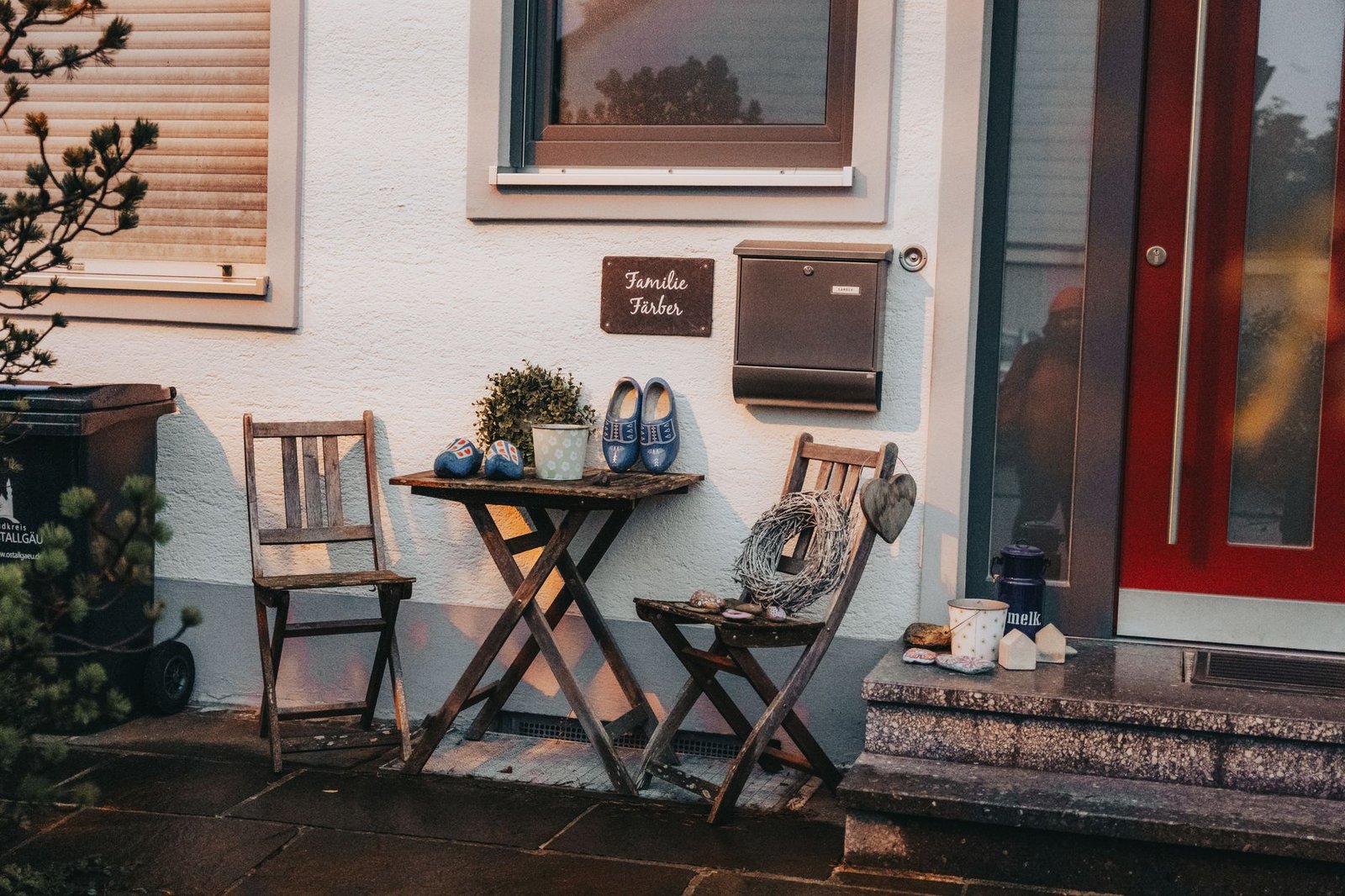 Charming entrance in Baiern, Germany with rustic chairs, table, and decorative elements.