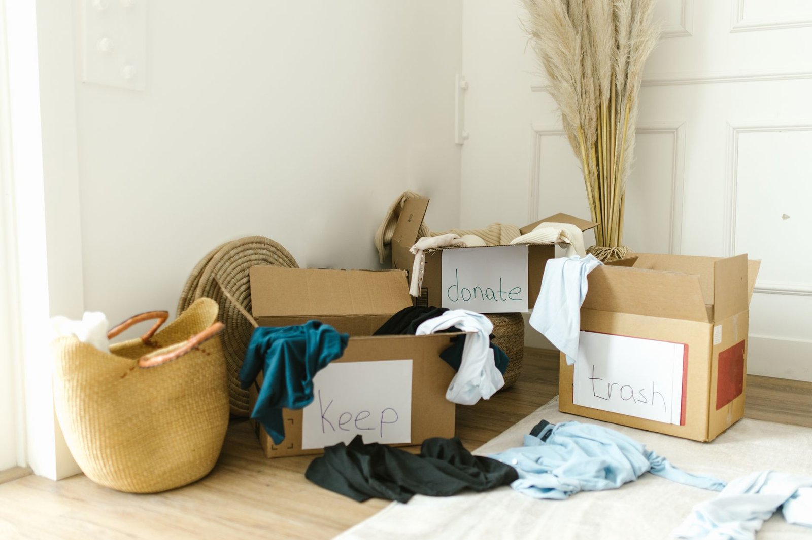 declutter challenge — Cardboard boxes labeled 'Keep', 'Donate', and 'Trash' for home decluttering.