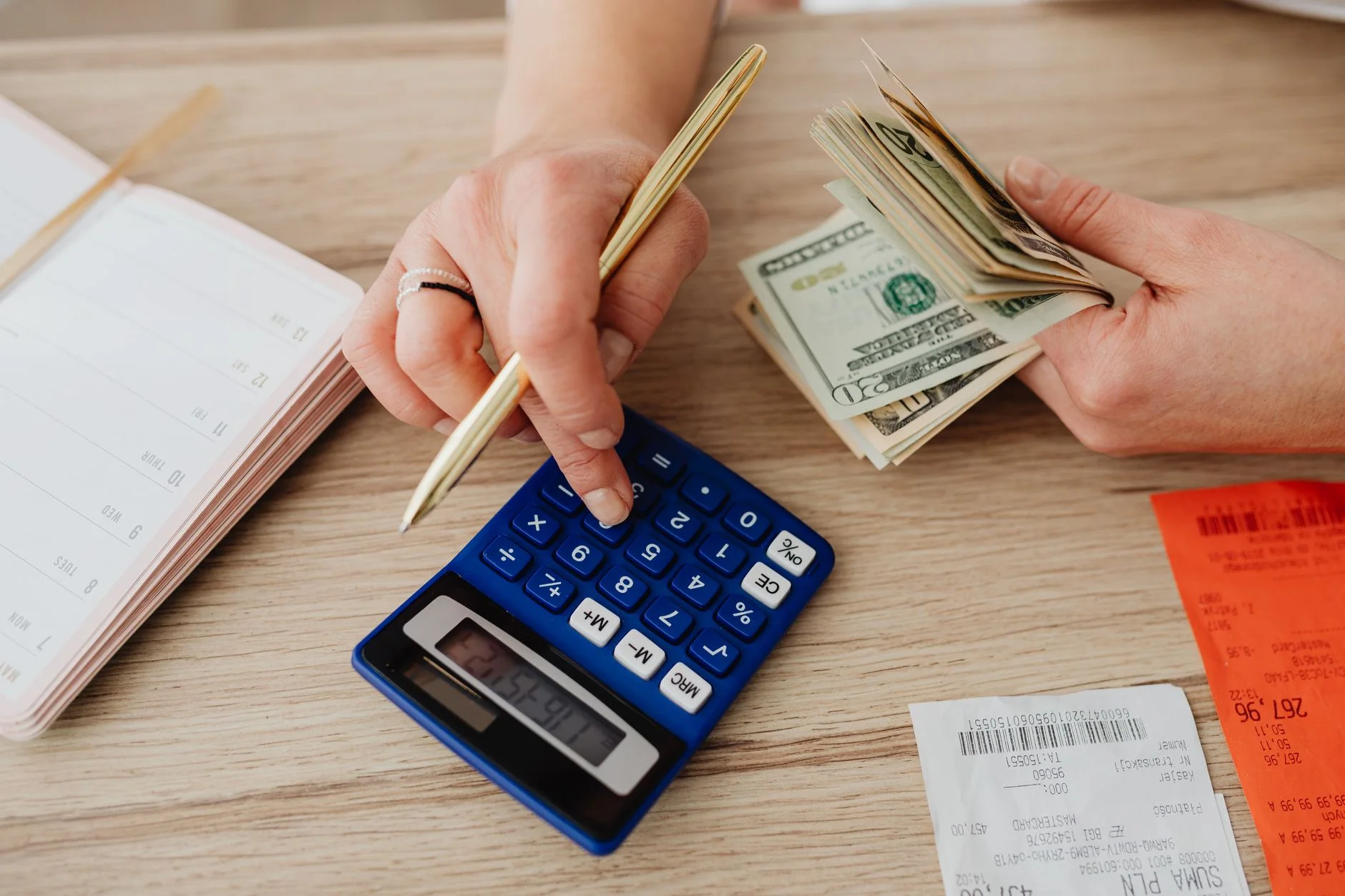 budgeting methods — Hands handling cash and calculator for budget planning. Modern financial scene.