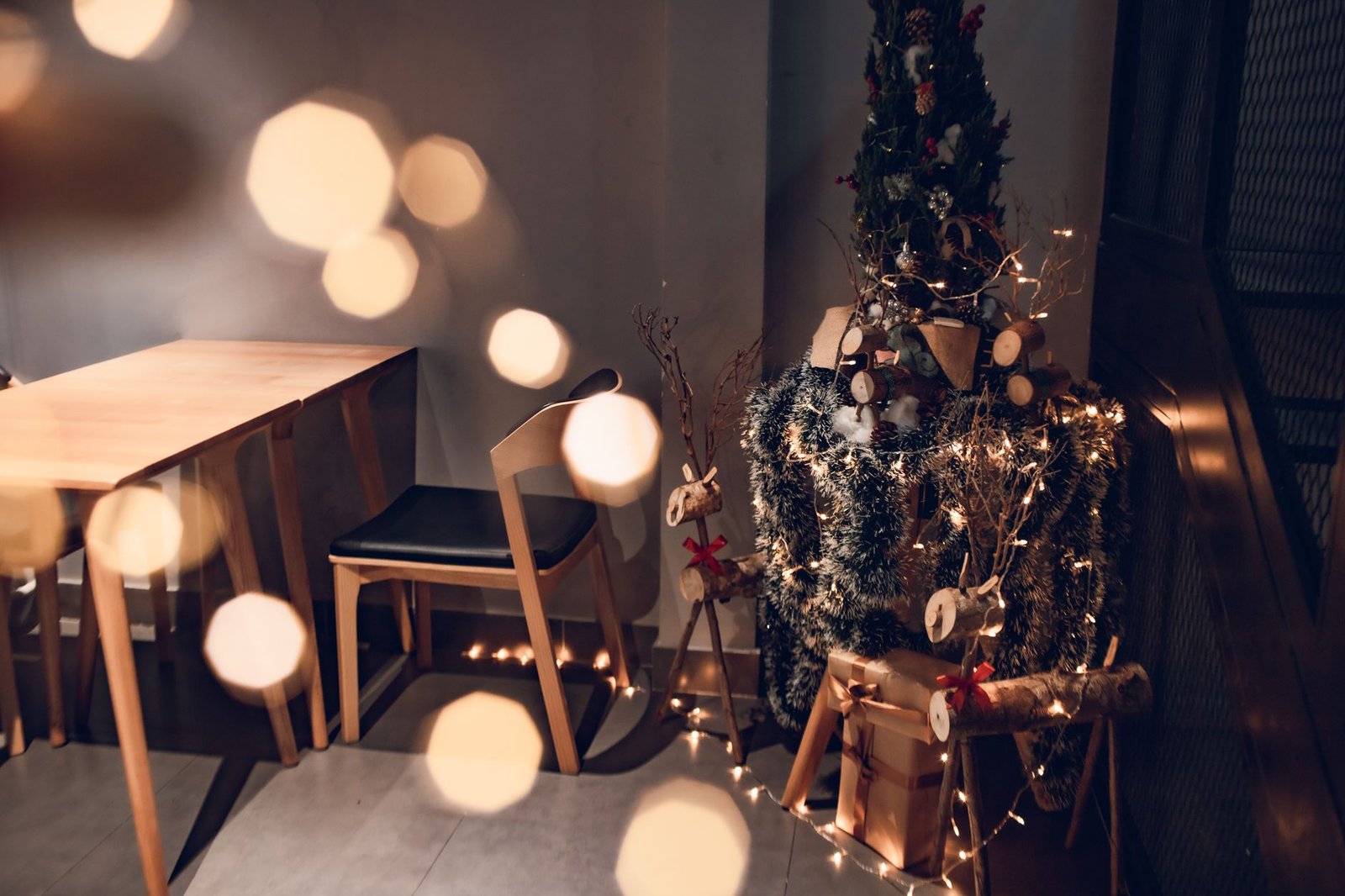 Warm and inviting Christmas corner with tree, gifts, and elegant lighting accents.