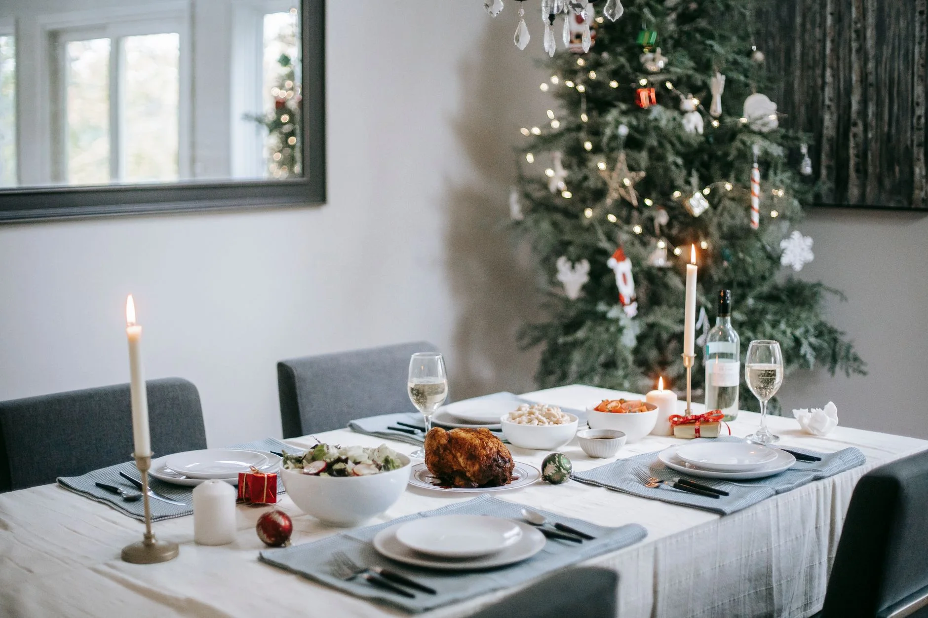 christmas dinner timeline — Elegant dining table set for a festive Christmas dinner with a beautifully decorated tree in the background.