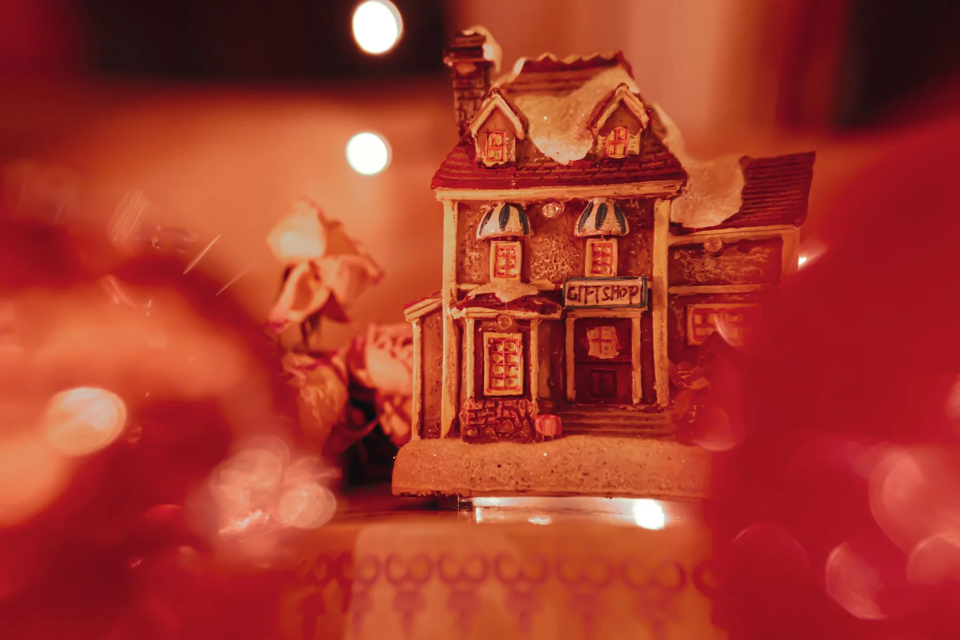 Cozy miniature Christmas house figurine with warm lights and festive charm.