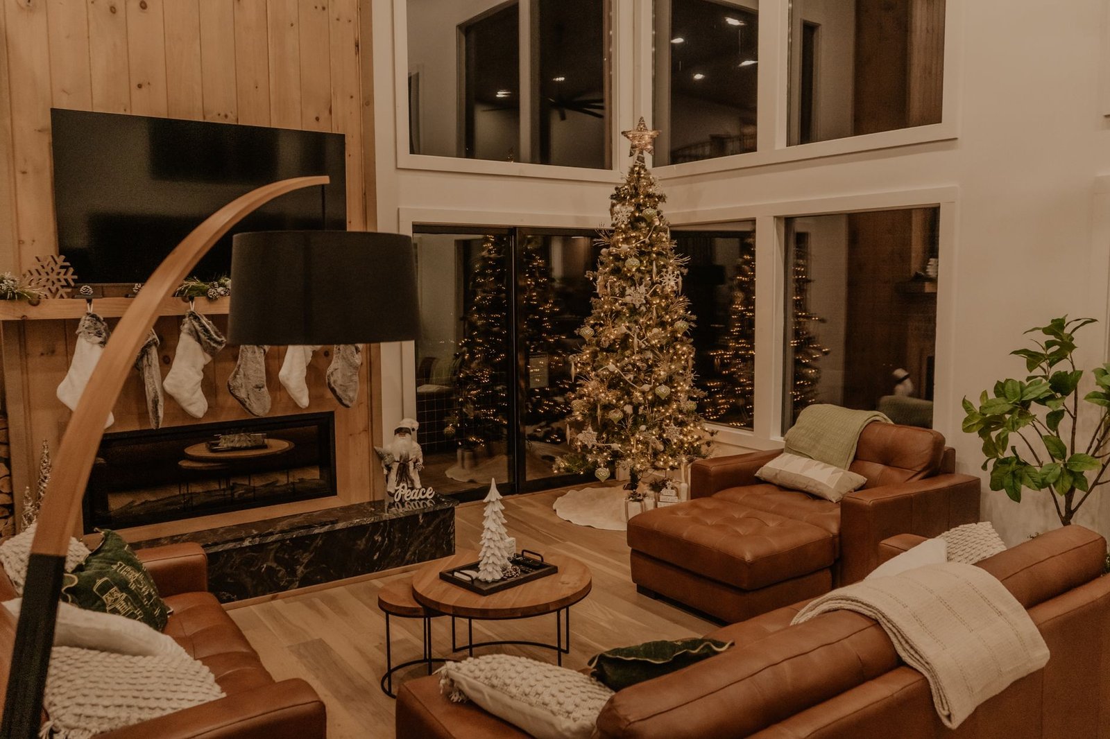 Warm living room with Christmas tree and fireplace, perfect for holiday ambiance.