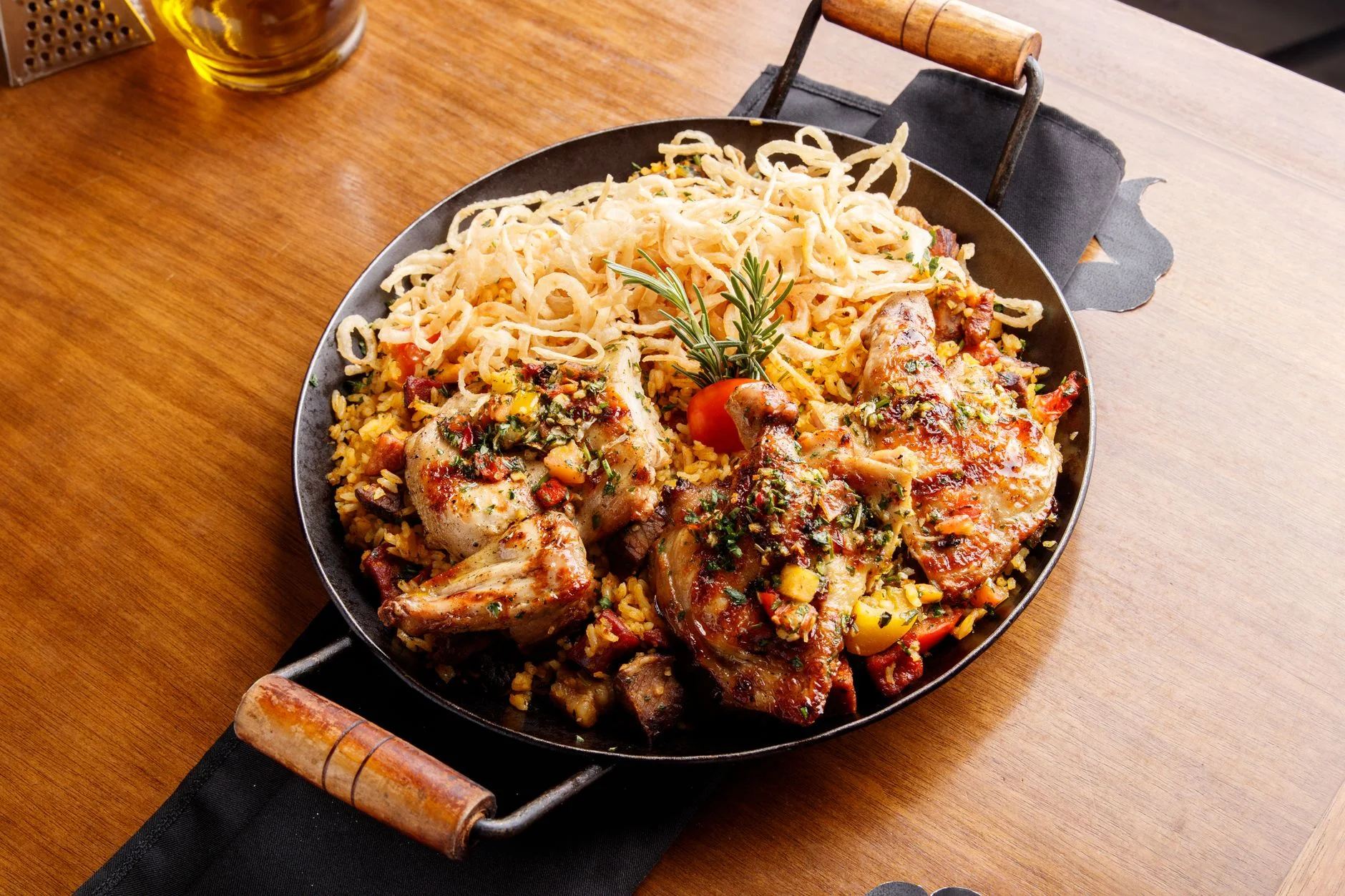 Delicious roast chicken served with seasoned rice and vegetables in a rustic pan.