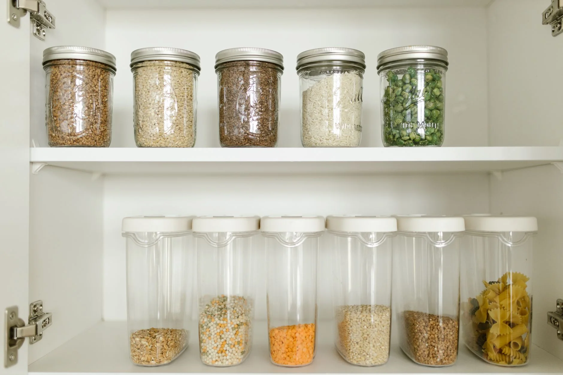 freezer organization — Neatly arranged pantry showcasing grains in glass jars and dry goods in plastic containers.