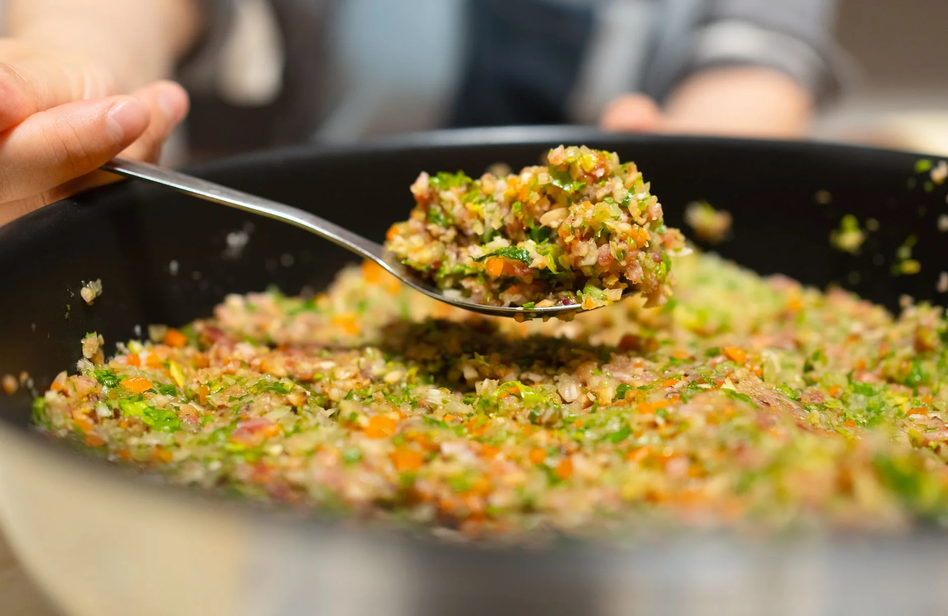 A delicious blend of vegetables and rice being freshly prepared in a pan during the day.