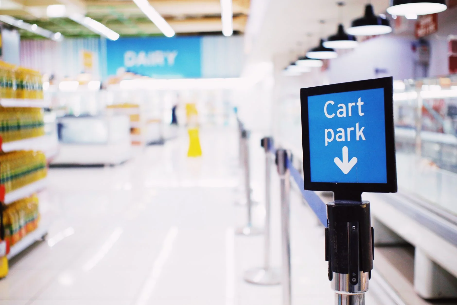 monthly grocery shopping — Blue signboard with inscription Cart park placed near counter with products in contemporary supermarket