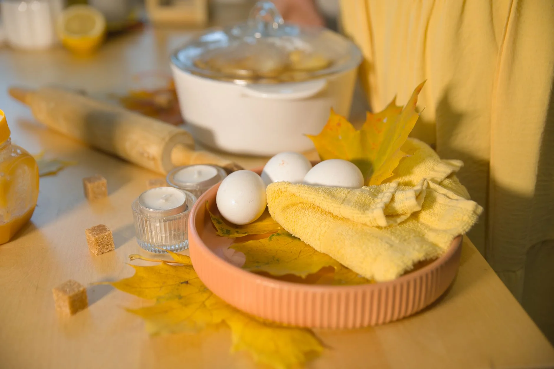 Autumn-themed baking setup with eggs, leaves, and kitchen tools.