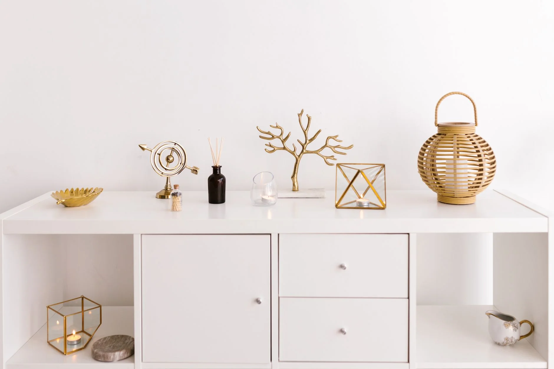 Sleek white cabinet with elegant gold decorations on a modern white background